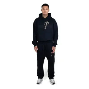 Dieses Bild zeigt den trendigen schwarzen Trapstar X Nofs Camo Trainingsanzug. Dieser Trainingsanzug besteht aus weichem Baumwollstoff und bietet hohen Tragekomfort. Ideal für Freizeit, Reisen und formelle Anlässe.